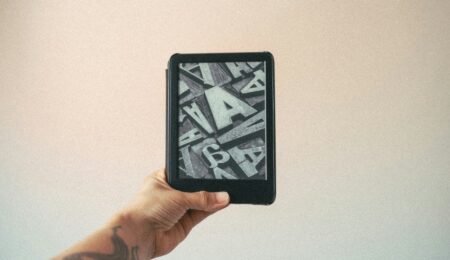 El libro electrónico en lengua española goza de buena salud. Así lo confirma el Informe Anual del Libro Digital 2025, que publica De Marque, antigua Libranda y principal distribuidora de libros digitales en español y lenguas cooficiales de España, y que ofrece la radiografía más completa del sector a ambos lados del Atlántico. El estudio cifra el mercado global del libro digital en español en 130 millones de euros durante 2025, con un crecimiento del 1,2% a nivel mundial y un 4,5% en España, que se consolida como el gran motor del sector con 74 millones de euros facturados y una cuota del 57%. Le siguen México (20%) y Estados Unidos (10 %). La cifra excluye libros de texto y académicos, así como operaciones directas de las editoriales en canales públicos o privados. Aunque la cuota global del libro digital en España se mantiene en torno al 6 % del mercado editorial, el informe recuerda un dato revelador: en los lanzamientos de novedades, el formato digital llega a suponer entre el 15% y el 25% de las ventas, e incluso un 40 % en títulos concretos. Una prueba de que, cuando el lector elige, el libro electrónico ya no es una rareza. Las bibliotecas, gran altavoz del libro digital Uno de los fenómenos más reseñables del año es el empuje del préstamo digital en bibliotecas, que crece un 11% respecto a 2024 y alcanza ya el 6,7 % del mercado. El servicio público eBiblio, impulsado por el Ministerio de Cultura, ha registrado casi 4,8 millones de préstamos (un 16,63% más) y casi 240.000 usuarios únicos (un 14,57% más). Las bibliotecas se confirman, así como una de las grandes puertas de entrada de la ciudadanía a la lectura digital. La venta unitaria a través de librerías y plataformas como Amazon, Apple, Google, Kobo, Casa del Libro, FNAC o Gandhi sigue siendo el modelo dominante, con un 87,6% del mercado, mientras que las plataformas de suscripción (Kindle Unlimited, Nextory, Scribd, 24Symbols o Skoobe) crecen un 2% y mantienen una cuota del 5,6 %. Qué leemos en digital El retrato del lector digital en español tiene rostro muy definido: siete de cada diez libros electrónicos vendidos son de ficción, con la novela contemporánea, el policiaco, la romántica y la histórica como grandes favoritas. La no ficción representa el 19%, con especial peso de la autoayuda, el desarrollo personal, los libros de sociedad y cultura, y las biografías. El infantil y juvenil completa el cuadro con un 10%. El fondo editorial pesa más que las novedades (66% frente al 34%), lo que refleja una tendencia saludable: el catálogo digital permite que los libros tengan vidas más largas y que obras publicadas hace años sigan encontrando lectores. En cuanto al precio, los libros electrónicos continúan siendo entre un 40% y un 60% más baratos que sus equivalentes en papel; en España, el precio medio sin IVA se sitúa en torno a los 8 euros. Un lector que subraya, busca y escucha Gracias a los datos de su aplicación Cantook App, De Marque ha podido analizar los hábitos reales de consumo y de uso de herramientas de navegación, accesibilidad e interacción con el contenido. El lector digital en español usuario de la aplicación Cantook navega por el índice de contenidos (33%), coloca marcadores de página (30%), hace búsquedas de términos (13%) y recurre a diccionarios integrados (7%). Una de las funcionalidades en mayor crecimiento es el text-to-speech —la lectura en voz alta sintetizada—, presente ya en el 12% de los actos de lectura, muestra de cómo la frontera entre leer y escuchar es cada vez más porosa. En esta línea, 2025 ha sido un año bisagra para la accesibilidad universal: el pasado 28 de junio entró en vigor en España la Ley 11/2023, que traspone la Directiva Europea 2019/882 e incluye expresamente los libros electrónicos y las plataformas de lectura. De Marque ha lanzado durante el año Cantook Access, una herramienta que aplica inteligencia artificial para ayudar a los editores a producir libros electrónicos accesibles para personas con discapacidad visual, auditiva, motora o cognitiva. Clubes de lectura y audiolibros: la conversación continúa Los clubes de lectura virtuales se consolidan como una de las estrategias más potentes de fomento lector, con iniciativas emblemáticas como la del Instituto Cervantes, que ha ampliado el debate literario más allá de las fronteras físicas. El fenómeno del audiolibro merece capítulo aparte: De Marque distribuye 26.100 títulos en español y lenguas cooficiales (el 52% del catálogo disponible) y sus ingresos han crecido un 16% en 2025, manteniendo un ritmo de doble dígito. A diferencia del libro electrónico, aquí el modelo dominante es la suscripción (más del 80%), seguida de la venta unitaria y el préstamo bibliotecario, que también sube con fuerza: en eBiblio, los préstamos de audiolibros han crecido un 13,82% durante el último año. A cierre de 2025, De Marque ha alcanzado los 286.270 títulos distribuidos en lengua española y lenguas cooficiales, procedentes de 2.600 sellos editoriales, desde grandes grupos hasta pequeñas editoriales independientes de España y Latinoamérica.