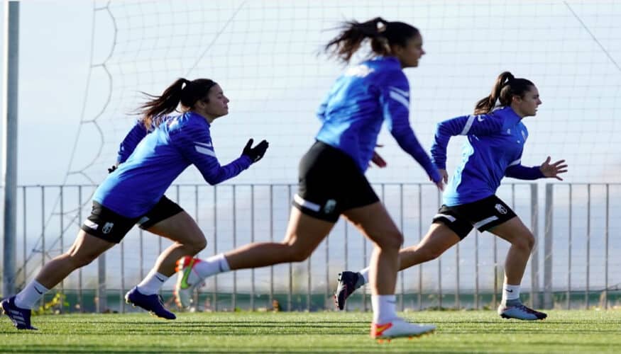 UN ESTUDIO DE LA UMA REVELA CÓMO LA POSICIÓN DE JUEGO Y EL NIVEL DEL RIVAL DETERMINAN EL ESFUERZO FÍSICO EN EL FÚTBOL FEMENINO El fútbol femenino ha experimentado un crecimiento sustancial en los últimos años, sumando en la actualidad más de 16 millones de jugadoras federadas a nivel mundial. Este auge ha venido acompañado de un creciente interés científico por estudiar las variables relacionadas con el rendimiento y la salud de las deportistas. En este contexto, un equipo de investigadores del Departamento de Didáctica de las Lenguas, el Arte y el Deporte de la UMA, en colaboración con IBIMA Plataforma Bionand, la Universidad de Granada y la Universidad Internacional de La Rioja, ha monitorizado a 18 jugadoras profesionales de un equipo de la Segunda División española a lo largo de 13 semanas competitivas. El objetivo principal del trabajo fue analizar las fluctuaciones de diversos descriptores de carga externa durante la semana, así como investigar la influencia de la posición en el campo y de factores contextuales (ubicación del partido, resultado o nivel del rival). Para realizar las mediciones con la máxima precisión, las deportistas utilizaron dispositivos de Sistema de Posicionamiento Global (GPS) de última generación a 10 Hz. Esta tecnología permite medir al milímetro el trabajo físico real ejecutado en términos de distancia, velocidad y aceleración. La demarcación, clave en el rendimiento El análisis de los miles de datos extraídos demuestra que el rol de juego es un factor determinante en el desgaste físico. Las métricas revelan diferencias muy acusadas en variables clave como la distancia explosiva o la carrera a alta velocidad (acciones por encima de los 18 km/h). Los resultados de este trabajo han sido publicados en la revista ‘Journal of Strength and Conditioning’. Asimismo, estos datos revelan que las jugadoras de banda (extremas e interiores) y las delanteras son las que acumulan mayor distancia a alta velocidad a lo largo del microciclo (es decir, la semana de trabajo entre dos partidos). De hecho, durante los días de encuentro, las futbolistas de banda llegaron a registrar valores hasta tres veces superiores en alta intensidad en comparación con las defensas centrales. Estas últimas mostraron, por lo general, los valores más bajos en indicadores clave como la distancia explosiva o la carga metabólica elevada. "Los resultados confirman que las jugadoras con roles más ofensivos están expuestas a mayores demandas de alta intensidad, tanto en competición como en entrenamiento", apunta Omar Sánchez Abselam, uno de los investigadores de la UMA responsable del estudio, quien añade que "comprender estas diferencias posicionales es fundamental para individualizar los programas de preparación física y, al mismo tiempo, para diseñar estrategias preventivas específicas para cada perfil de jugadora". El impacto del nivel del adversario Además de las diferencias individuales por posición, el estudio evaluó la influencia del contexto competitivo. En este apartado, los investigadores descubrieron un dato muy llamativo que desafía la intuición táctica: la carga externa del microciclo es significativamente mayor cuando el equipo se enfrenta a los rivales de menor estatus o peor clasificados. Este sobreesfuerzo, que se traduce en un incremento de entre un 15% y un 20% en las distancias totales recorridas y en los esfuerzos de alta intensidad, es superior al registrado frente a equipos de la parte alta de la tabla. Los autores sugieren que "esta mayor demanda condicional en el microciclo se puede atribuir a una estrategia intencionada del staff técnico que, en previsión de una teórica menor exigencia impuesta por un rival inferior, aproveche para elevar la carga semanal” La importancia del tapering La investigación confirmó además que las demandas varían drásticamente en función de la proximidad del partido. El día del encuentro supone la mayor exigencia para las futbolistas, acumulando más del 50% de la distancia recorrida a alta velocidad de toda la semana. De otro lado, el día previo al encuentro es, sin embargo, la jornada menos exigente del microciclo (representando solo un 14% de la carga máxima semanal). Esta reducción subraya la importancia del tapering (puesta a punto) para garantizar que las futbolistas lleguen en óptimas condiciones y sin fatiga acumulada. Estos hallazgos suponen una importante aportación práctica al ámbito del rendimiento en el fútbol femenino de élite. En este sentido, los expertos señalan que estas conclusiones deben ser una herramienta de gran utilidad para preparadores físicos y cuerpos técnicos. Asimismo, recomiendan diseñar los programas de entrenamiento y planificar el microciclo de forma individualizada, teniendo en cuenta cómo la posición de juego y otros condicionantes como el calendario o el nivel del rival pueden alterar los valores de carga de cada futbolista. Referencia bibliográfica: Sánchez-Abselam, O., González-Fernández, F. T., Castillo-Rodríguez, A., y Onetti-Onetti, W. (2026). External load of professional female soccer players in the competitive microcycle: Influence of playing position and contextual variables. Journal of Strength and Conditioning Research, 40(3), e324–e332. https://doi.org/10.1519/jsc.0000000000005387