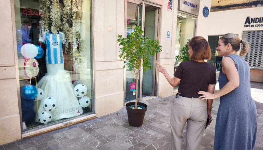 Los comercios del centro se visten de blanquiazul para animar al Málaga CF en la semana más decisiva